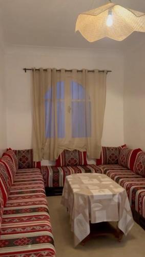 a living room with two couches and a table at front of beach apartement taghazout in Taghazout