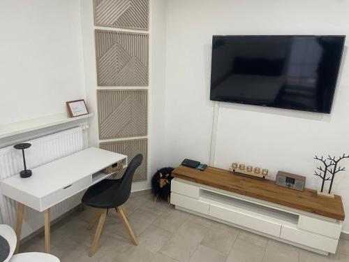 une pièce avec un bureau et une télévision sur un mur dans l'établissement private parking,old town,52m2,terrace,no stairs, newly renovated,, à Ingolstadt
