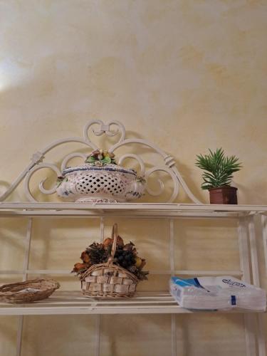 a shelf with baskets and a tea pot on it at Casa Flora in Civitella dʼAgliano