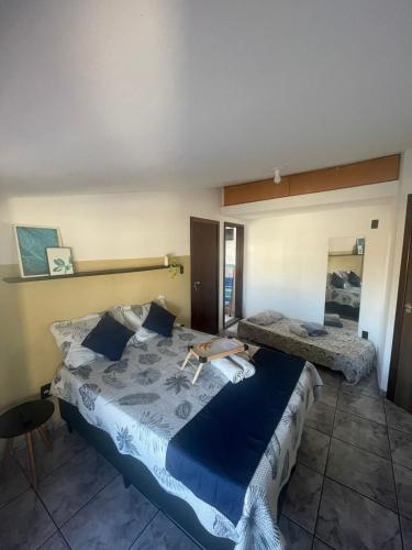 Schlafzimmer mit einem großen Bett mit blauer Decke in der Unterkunft Apartamento Sol Nascente no centro da cidade in Cruz das Almas