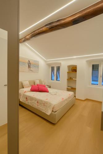 a bedroom with a large bed with red pillows at WELCOME RIVIERA Mazzini 77 appartamento lusso nel centro di Rapallo,WIFI, condizionamento in ogni stanza, attrezzato con tutto quello che serve in una casa, per un soggiorno da favola, parcheggio a pagamento 15euro al giorno da prenotare in anticipo in Rapallo