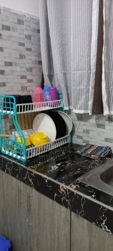 a kitchen counter with a dish drying rack next to a sink at Ekebute BnB in Mombasa