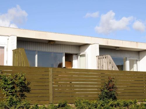 a house with a wooden fence in front of it at 4 person holiday home in Rømø-By Traum in Rømø Kirkeby