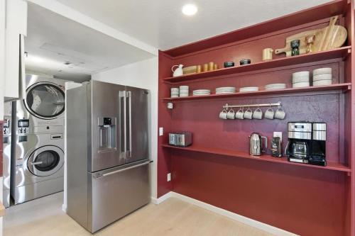a kitchen with a refrigerator and a red wall at The Cowboy Social Unit 12 in Williams