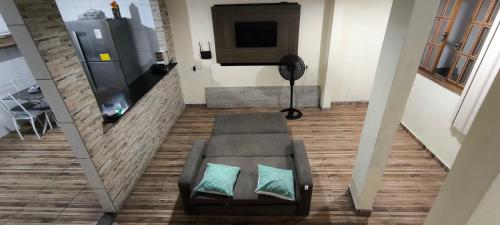 a view of a living room with a couch and a television at Casa com garagem no coração de Arraial! in Arraial do Cabo