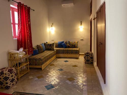 a living room with two couches and a window at Riad la Mentha in Fès