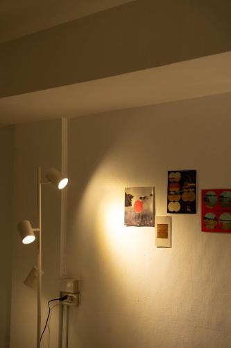 a light on a wall with pictures on it at Roni House Thonglor in Bangkok