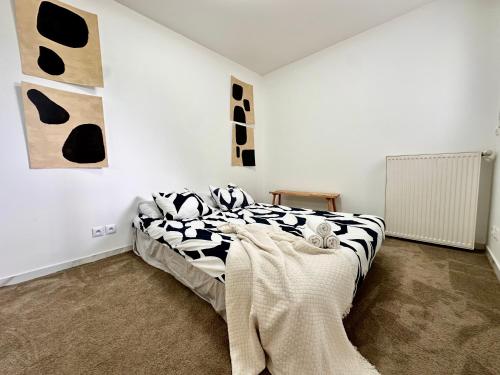 1 dormitorio con 1 cama con sábanas blancas y negras en KAALA RIVERSIDE Deluxe apt entre Disney et Paris free Parking, en Lognes