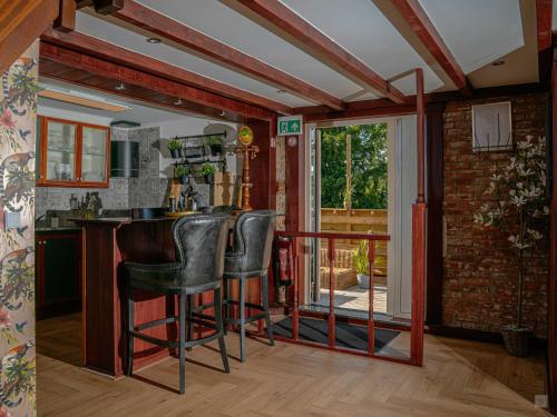 a kitchen with a bar with leather stools at SuiteXO in Ons Belang