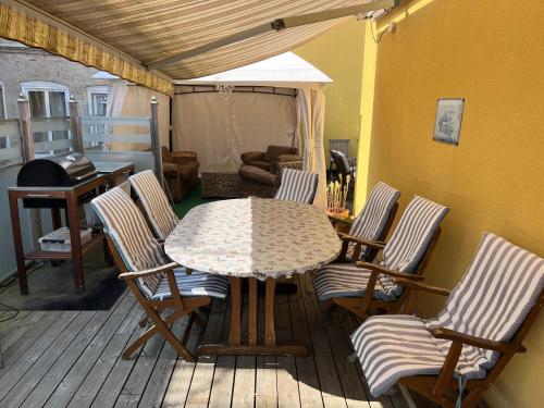 a patio with a table and chairs on a deck at Sveriges minsta Hotell! Hôtel Gruyère in Landskrona