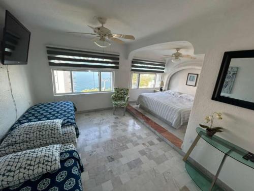 1 dormitorio con 1 cama, ventilador y ventanas en Manzanillo Beautiful Views Private Pool, en Manzanillo