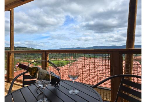 a table with two glasses of wine on a balcony at Tiny d'Monts in Brullioles