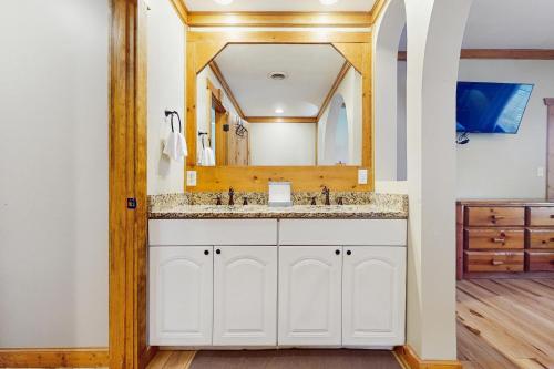 un baño con lavabo y espejo en Smoky Haven, en Pittman Center