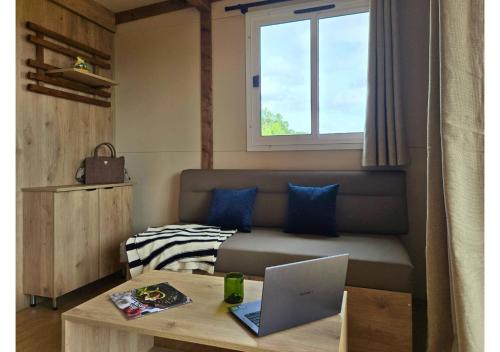 a room with a couch and a laptop on a table at Tiny d'Monts in Brullioles