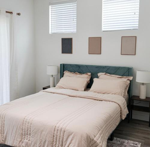 1 dormitorio con 1 cama con paredes blancas y 2 ventanas en Townhome in North Austin, en Austin