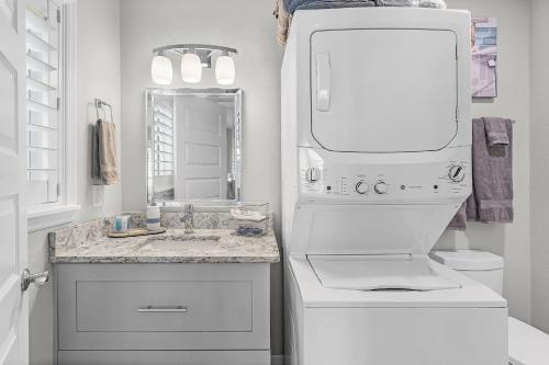 a white bathroom with a sink and a mirror at Place your bet on a WINNING Vacation Retreat - Peace River Pair-A-Dice - Roelens in Punta Gorda