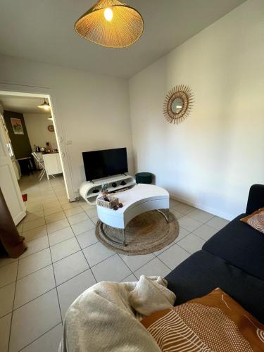 a living room with a couch and a table at Charming house with terrace in Laval