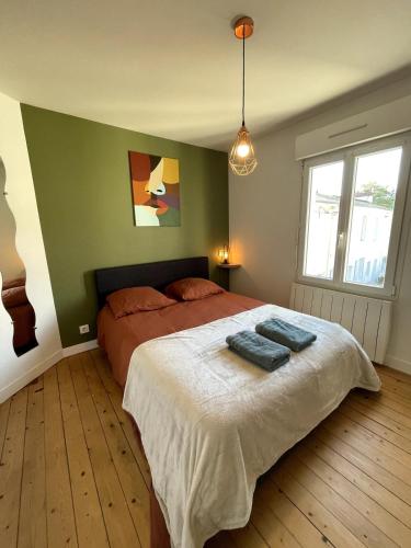 a bedroom with a bed with two blue towels on it at Charming house with terrace in Laval
