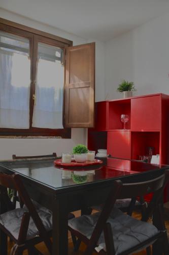 a kitchen with a table with chairs and red cabinets at Villa Rosa Canfranc, tu refugio en el corazón del Pirineo Aragonés in Canfranc