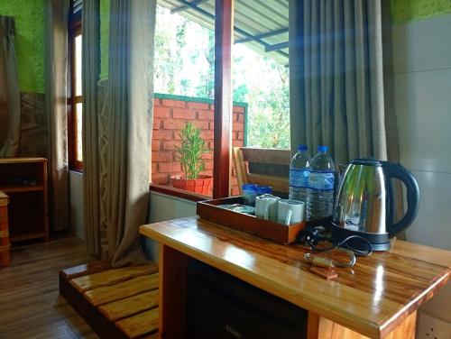a wooden table with water bottles on top of it at NETHSARA cottage in Ella