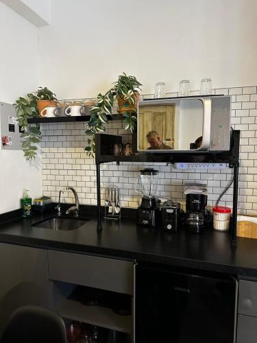 a kitchen counter with a sink and a mirror at Enzo in Santeagueda