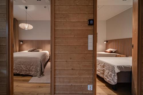 a bedroom with two beds and a sliding door at Levillas Levin Cranberry C24 in Levi