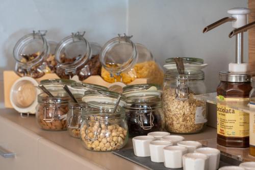 Una encimera de cocina con frascos de comida y otros ingredientes. en Hotel Iride & Spa bed&breakfast, en Cesenatico