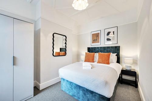 Un dormitorio con una cama grande con almohadas naranjas. en Balfour House - Air Host & Stay - Sleeps 8, free parking, en Litherland