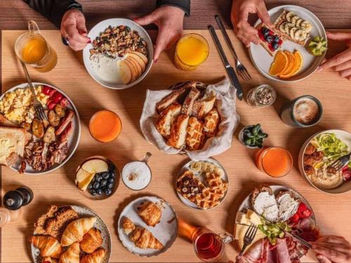 ein Tisch mit vielen Tellern voller Essen in der Unterkunft Hotel Mercure Château de Fontainebleau in Fontainebleau