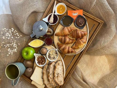 ein Tablett mit Croissants und anderen Speisen auf einem Tisch in der Unterkunft Hotel Mercure Château de Fontainebleau in Fontainebleau