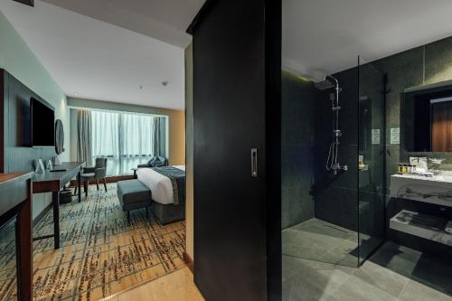 une chambre d'hôtel avec un lit et une salle de bain dans l'établissement VERTA Al Olaya Hotel, à Riyad
