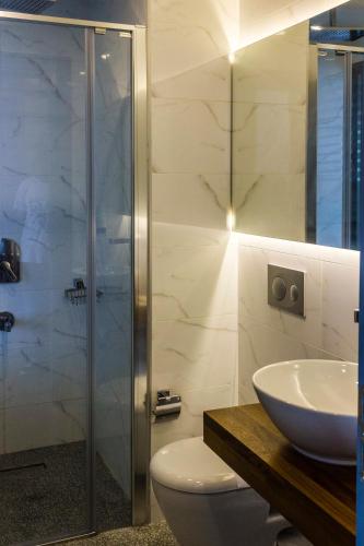 a bathroom with a shower and a toilet and a sink at Port Marina Hotel in Karatas