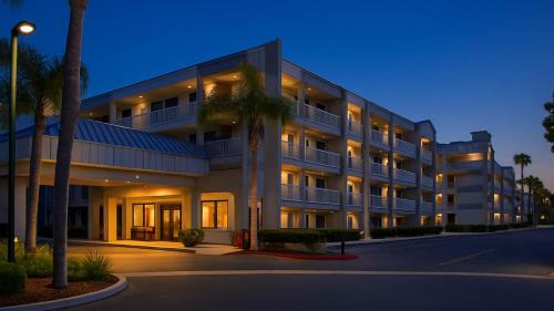 a large building with palm trees in front of it at Motel 6-Anaheim, CA - Maingate in Anaheim