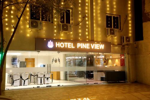 a hotel entrance with chairs in front of a building at Hotel Pine View in Rajkot