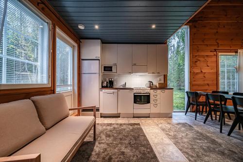 a kitchen and living room with a couch and a table at Aurelfox Chalet A by Aavalevi in Levi