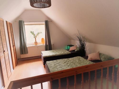 Zimmer im Dachgeschoss mit 2 Betten und einem Fenster in der Unterkunft Monteur Ferienwohnungen Auetal in Bad Bodenteich