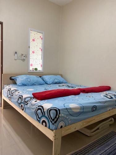 a bedroom with a bed with a blue comforter at kubu home stay in Ban Ko Sawat