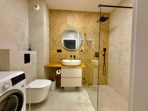 Un baño con lavabo, inodoro y espejo. en Jarzebinowa Loft III by JumpInHere, en Nowy Dwór Mazowiecki