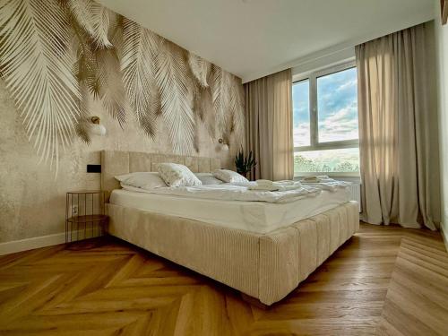 Un dormitorio con una cama grande y una ventana grande. en Jarzebinowa Loft III by JumpInHere, en Nowy Dwór Mazowiecki