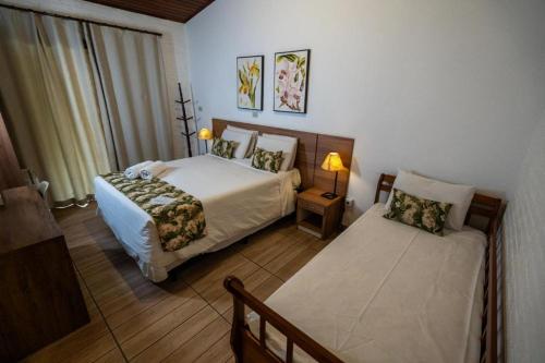 เตียงในห้องที่ Vale das Orquídeas Pousada