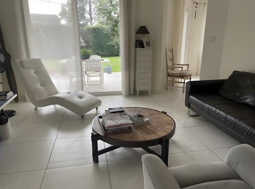 a living room with a couch and a table and chairs at Chambre d'hotes à Laroin in Laroin