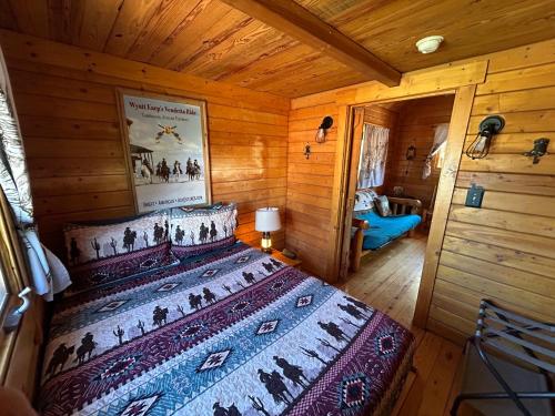 a bedroom with a bed in a wooden cabin at Katie's Cozy Cabins in Tombstone