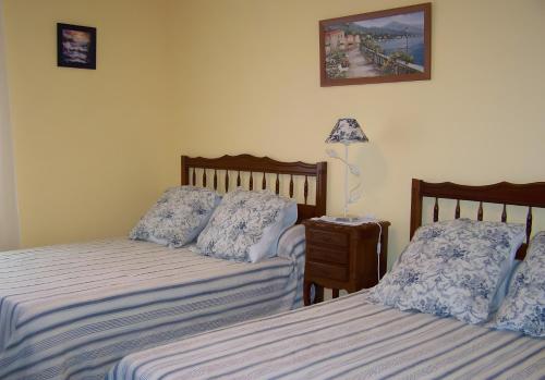 Un dormitorio con dos camas y una lámpara sobre una mesa. en Appartement Handia, en Amotz