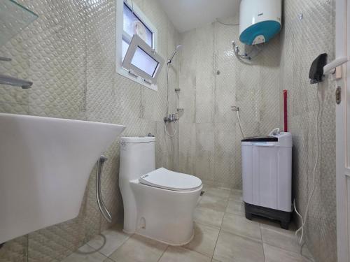 a bathroom with a white toilet and a shower at B21 Studio At Dar Al Hoboor دار الحبور in Seeb