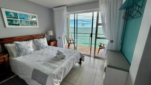 a bedroom with a teddy bear sitting on a bed at Langebaan Beach Towers in Langebaan