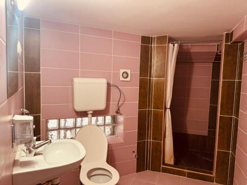 a pink bathroom with a toilet and a sink at Opera Central Stay in Budapest