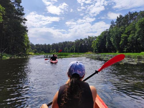 a woman in a kayak on a river with a man at Domek Leśna Przystań 