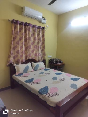 a bedroom with a bed with a floral bedspread at Johan home stay AC in Thiruchendur