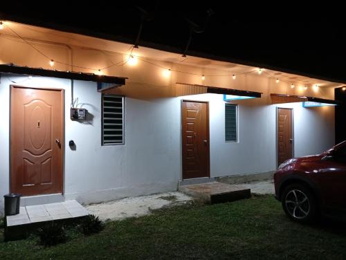 a house with two doors and a car parked outside at ibilik Changloon in Changlun
