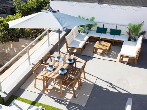 a patio with a table and chairs and an umbrella at Live Güimar Las Pirámides in Güimar